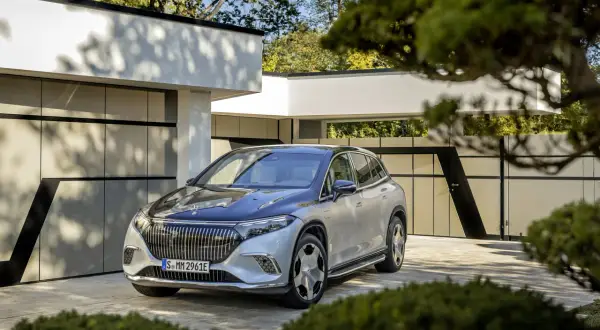 Elegancki Maybach SUV w kolorze srebrno-czarnym zaparkowany przed nowoczesnym domem.
