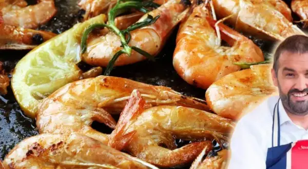 Gambones a la plancha dorados y jugosos, con limón y romero. Un chef sonriente los presenta.