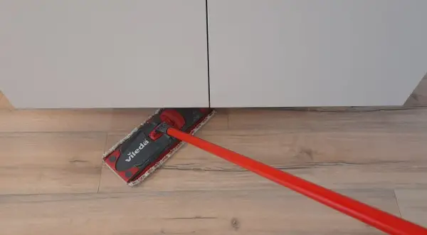 Mocio Vileda rosso pulisce il pavimento in legno, mostrando come smacchiare il legno con facilità.