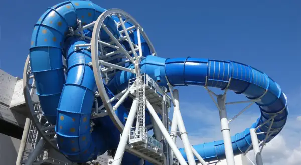 Aquapark Reda: niebieska zjeżdżalnia z rekinami, wirująca konstrukcja z rur, podniebna przygoda.