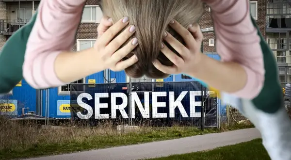 Person med händerna i håret framför en blå byggbarack med texten SERNEKE. En symbol för Serneke konkurs.