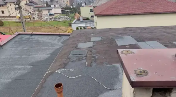 Dach płaski z papą, przygotowany do ocieplenia nakrokwiowego. Widoczny komin i rynna.