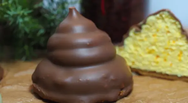 Chokladöverdragen maräng med en bit av en gul kaka med apelsinskal. Undrar om man kan frysa maräng?