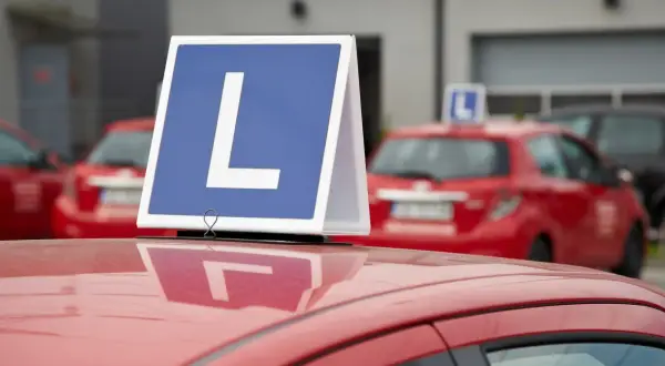 Nauka jazdy w Czechach: czerwone auto z literą "L" na dachu. To znak dla uczących się, jak zrobić prawo jazdy w Czechach.