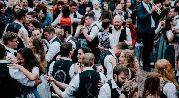 Menschen in Tracht tanzen ausgelassen. Ein Mann spielt Trompete. Hier ist heute Kirchweih in Franken!