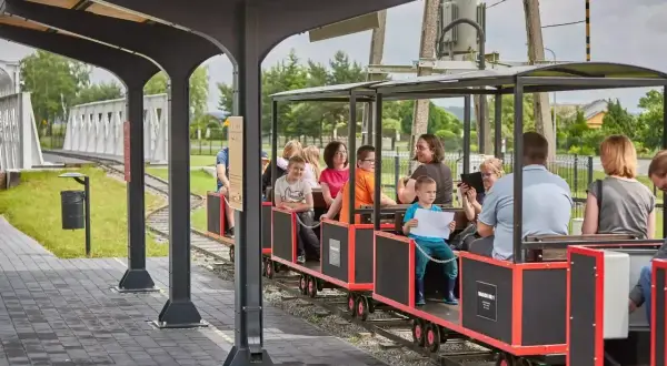 Rodzinny przejazd kolejką wąskotorową to świetne zwierzyniec atrakcje dla dzieci. Uśmiechnięte twarze i radosne okrzyki świadczą o udanej zabawie.