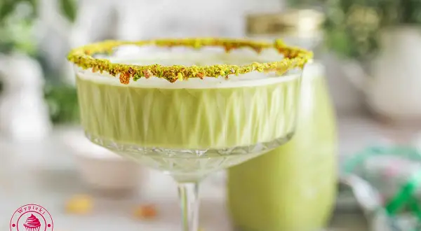 Zielony likier pistacjowy w kieliszku z posypką z pistacji. Idealny na specjalne okazje, oto prosty likier pistacjowy przepis.