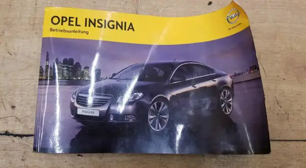 Okładka instrukcji obsługi Opel Insignia z widokiem na ciemny samochód na tle nocnego miasta.