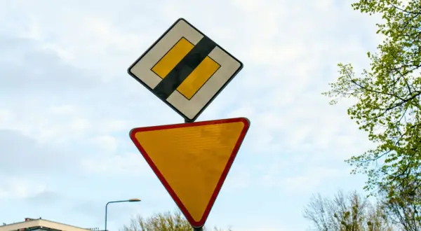 Dwa znaki drogowe: "ustąp pierwszeństwa" (trójkąt) i "koniec drogi podporządkowanej" (kwadrat z pasem).