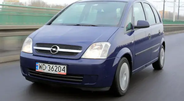 Niebieski Opel Meriva B jedzie po moście.