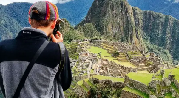 Turysta robi zdjęcie Machu Picchu. To idealne miejsce, by sprawdzić, kiedy najlepiej lecieć do Peru, by podziwiać te cuda.