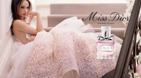 Kobieta w tiulowej sukni trzyma flakonik Miss Dior Blooming Bouquet.