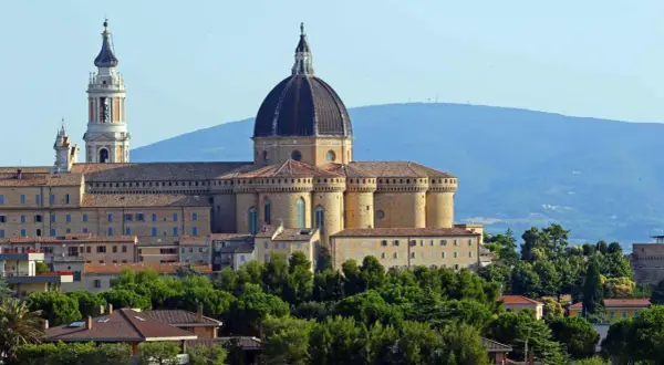 Basilica della Santa Casa a Loreto, vicino Ancona, con la sua imponente cupola e campanile, circondata da verde.