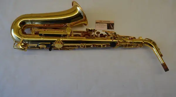 Glänzendes goldenes Saxophon mit einer kleinen Karte, die eine Saxophon-Beschriftung zeigt.