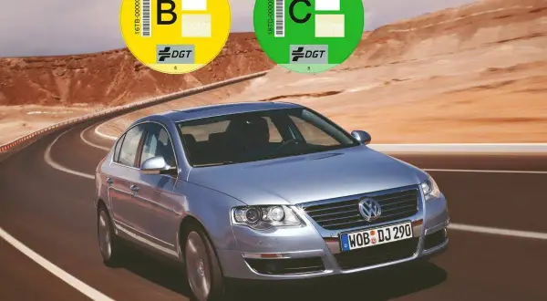 Un coche plateado en una carretera desértica con pegatinas DGT. Averigua como saber si mi coche es Euro 6.