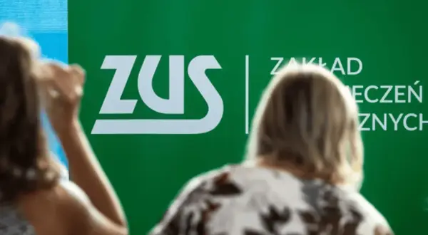 Ludzie przed zielonym banerem ZUS. Dyskusja o składce zdrowotnej 2026.