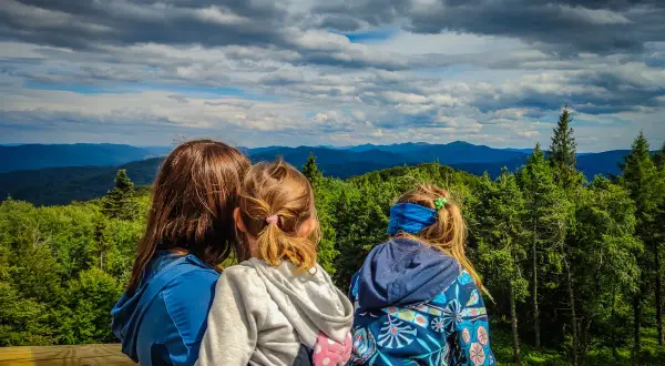 Rodzina podziwia widok na Bieszczady. To wspaniałe atrakcje dla dzieci, które pokochają górskie wędrówki i piękne krajobrazy.