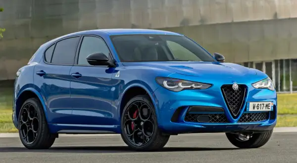 Niebieskie Alfa Romeo Stelvio z czarnymi felgami i czerwonymi zaciskami hamulcowymi. Sprawdź aktualną alfa romeo stelvio cena.