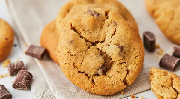 Saftige Schokoladenkekse, perfekt für alle, die Kekse ohne Ei lieben. Kleine Schokoladenstücke und Krümel liegen verstreut.