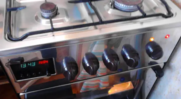 Instrukcja piekarnika Mastercook Wrozamet. Cyfrowy wyświetlacz pokazuje 13:43 i 100°C. Dwie lampki kontrolne świecą się na pomarańczowo i czerwono.