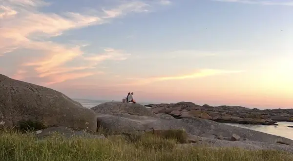 Två personer njuter av solnedgången vid Solvik camping Smögen. En idyllisk kväll vid havet.