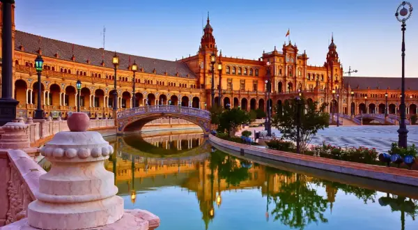 Plaza de España en Sevilla, uno de los lugares de España para visitar. Reflejos dorados en el canal y arquitectura impresionante.