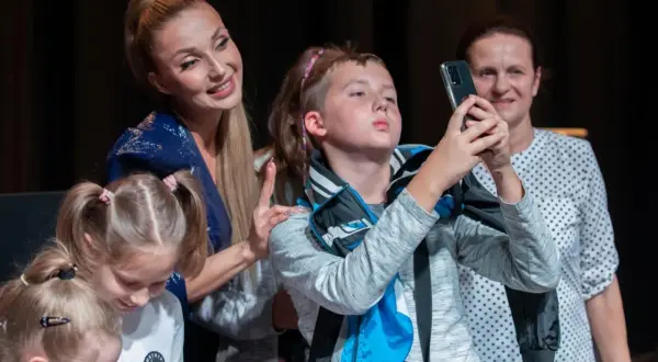 Cleo z dziećmi na scenie, robią sobie selfie.