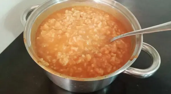 Gęsta zupa pomidorowa z ryżem w garnku, gotowa do podania. Idealna, by dowiedzieć się, jak zaprawić zupę pomidorową.