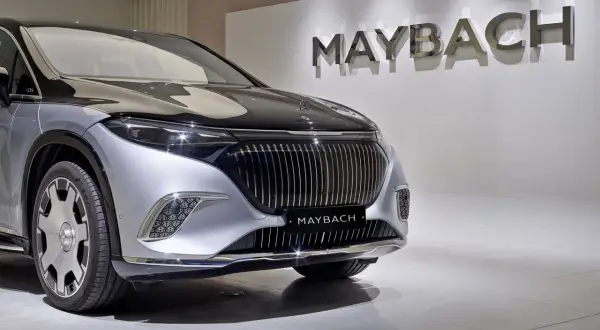 Elegancki Maybach błyszczy na tle logo marki. Poznaj jego wyjątkową **maybach cena** i poczuj luksus.