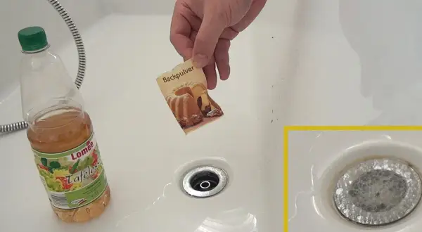 Hilfe bei verstopftem Waschbecken: Backpulver und Essig werden in den Abfluss gegeben, um die Verstopfung zu lösen.