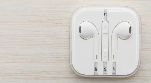 Białe słuchawki w etui. Czy do iPhone pasują inne słuchawki? Tak, ale te są oryginalne.