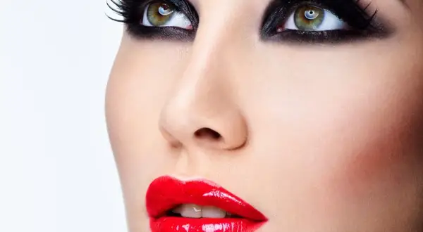 Occhi con smokey eyes e labbra sensuali con trucco con rossetto rosso brillante.