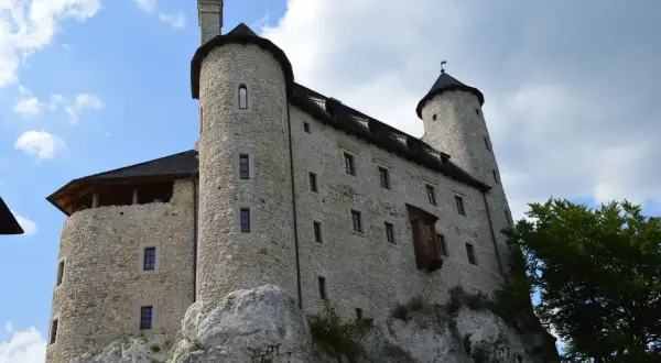 Kamienny zamek na skale, jedna z głównych atrakcji Bobolic, z wieżami i murami obronnymi.