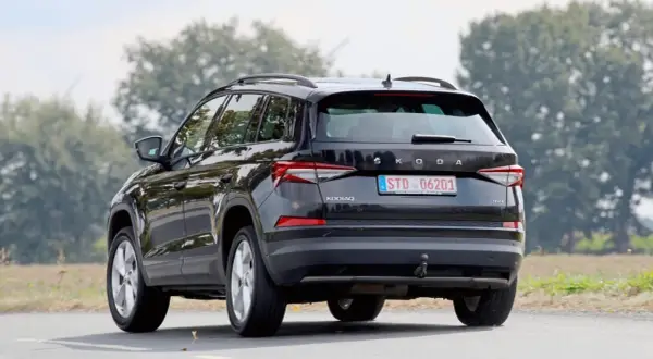 Svart Skoda Kodiaq kör på en landsväg. En snål bil som är perfekt för familjen och äventyr.
