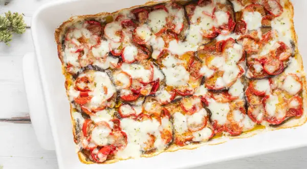Melanzane al forno con pomodoro e mozzarella filante, un piatto che dimostra i **100 modi per cucinare le melanzane**.