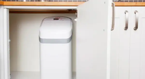 Un adoucisseur nouvelle génération, blanc et compact, est discrètement installé sous l'évier de la cuisine.