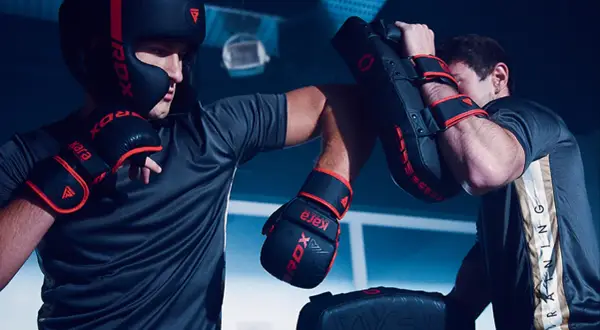 Two boxers train intensely, practicing punches and blocks. This focused training is key to learning how to win a boxing match.