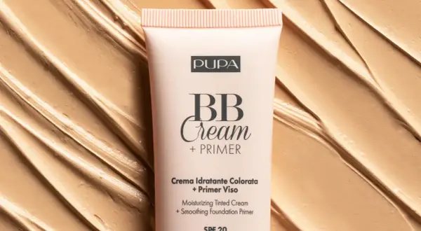 Tubo di BB Cream Pupa su sfondo di texture cremosa. Scopri come mettere la bb cream per un incarnato perfetto.
