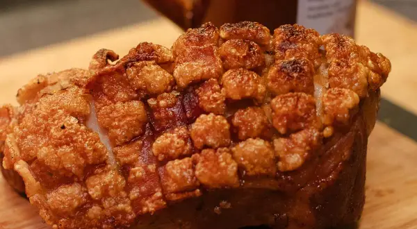 Knuspriger schweineschulterbraten mit perfekt aufgeplatzter Schwarte, bereit zum Genuss.