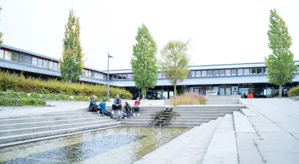 Studierende entspannen sich auf den Treppen vor der Uni Schwerin.