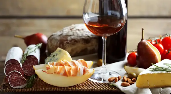 Pyszne wino z Włoch, ser, salami, pieczywo i owoce tworzą idealną przekąskę.