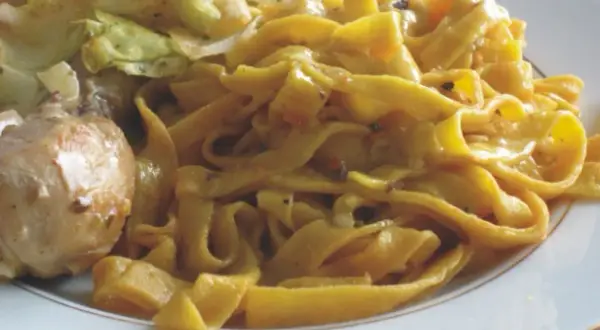 Pyszne tagliatelle z kurczakiem i warzywami na talerzu.
