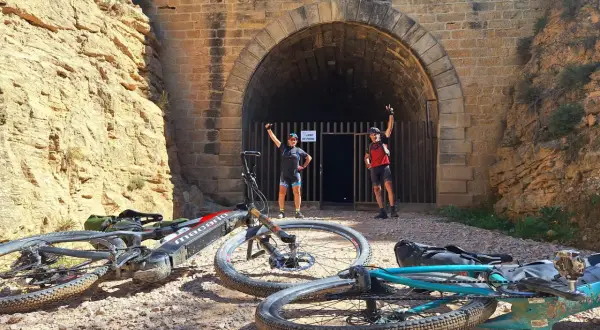 Ciclistas posan ante un túnel, una parada interesante que ver cerca de Alcañiz.