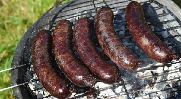 Pięć soczystych kaszanek z grilla, rumieniących się na ruszcie nad żarem. Idealne na letnie popołudnie.