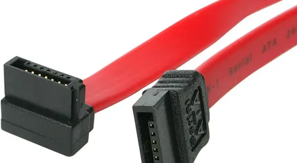 Czerwony kabel SATA z czarnymi złączami, gotowy do podłączenia dysku. Różnica między ATA a SATA jest widoczna w złączach.