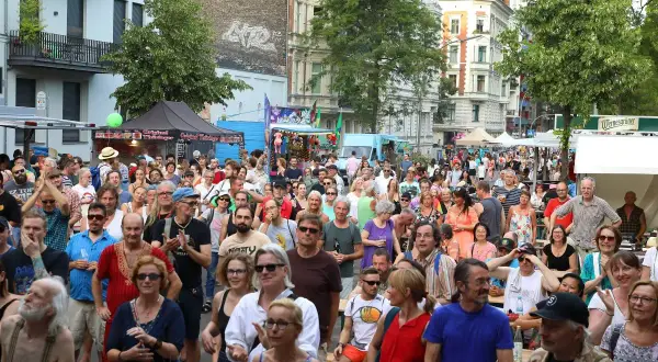 Menschenmenge feiert beim Kreuzberg Festival. Bunte Stände und ein belebtes Straßenfest mit vielen Besuchern.