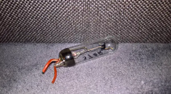 Szklana bańka z elementami elektronicznymi i czerwonymi przewodami. Tak wygląda prostownik, który kiedyś zasilał urządzenia.