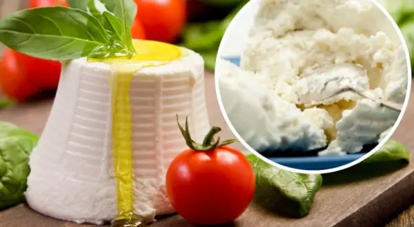 Świeża ricotta z oliwą i bazylią, obok pomidorki. W tle widać jej kremowy skład.