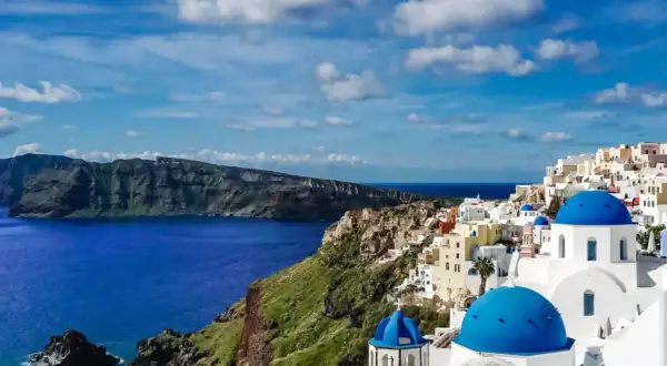 Santorini w maju: błękitne kopuły kościołów, białe domy na klifie i lazurowe morze. Idealna pogoda na zwiedzanie.