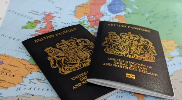 Dwa brytyjskie paszporty leżą na mapie Europy, sugerując podróż. Czy do Wielkiej Brytanii potrzebny jest paszport? Tak, dla większości podróżnych.